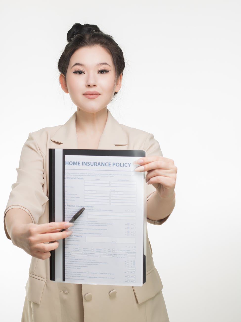 woman in corporate attire holding a home insurance policy